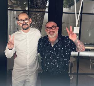 Chef Aitor Zabala of SOMNI with Brad K. Block of BKB Enterprises, standing inside SOMNI restaurant smiling, both giving peace signs