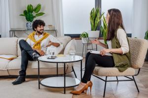 Latino man sitting across from therapist in comfortable office setting during therapy session