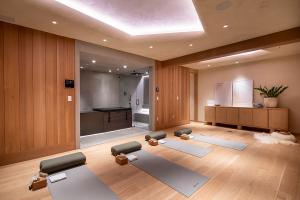 Interior view of a wellness room with yoga mats, warm wood finishes, and soft lighting, designed to promote health and well-being.