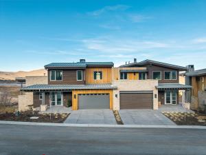 Modern mountain home exterior with stone and wood facade, designed for WELL certification in Park City, Utah.