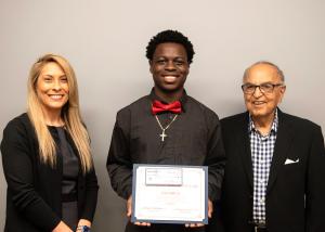 a woman, a student and a man pose at an award ceremony