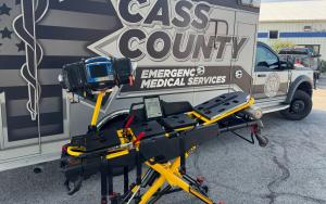 Photo of an emergency stretcher equipped with Hinckley Medical’s OneDose® and OneWeight® in front of a Cass County EMS ambulance.
