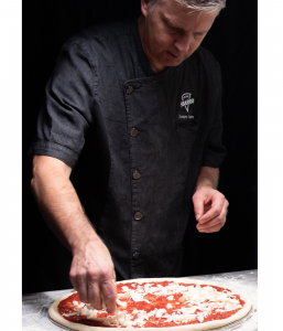 Chef topping the Sbarro Pizza with Shredded Mozzarella Cheese