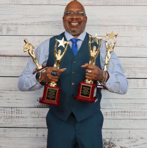 A picture of Michael Stokes hold awards