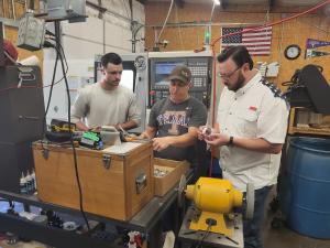 George Mayfield inspects a part with machine shop owner, waylon gurley