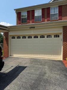 Brown wooden-style garage door installed on a residential property in Potomac, Maryland.