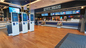 The foyer at Scott Cinemas' branch in Bridgwater, with a range of digital displays, ticket kiosks , and a large display showing trailers  to entertain customers