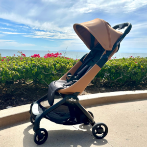 the new miro compact stroller shown in mocha cream color way in an outdoor setting with California waterfront in background in Laguna Beach.