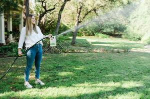There’s been a lot of talk about ticks lately and people are concerned Woman sprays Wondercide Flea & Tick spray on yard for tick prevention.