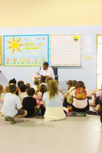 Chef Serge Krikorian of Vibrant Occasions Catering reads "The Smart Cookie" to children at Faith Academy's after-school program as part of the company's community outreach initiatives.