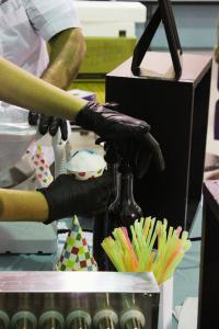 Vibrant Occasions Catering team members prepare fresh snow cones as special treats for the children at Faith Academy during Chef Serge's community reading visit.
