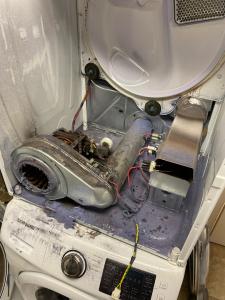 Open dryer undergoing repair by Fast Appliance Repair Pro technician, replacing damaged parts in Toronto.