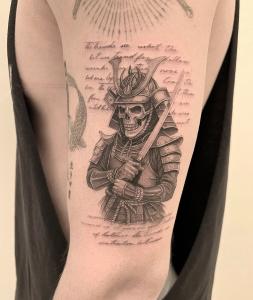 Bang Bang Alum & Fine-Line Tattoo Artist Derrick Johnson Opens Private NYC Studio and Launches Online Booking 13 Detailed black-and-gray tattoo of a skeleton samurai in armor with handwritten script in the background, inked on upper arm.