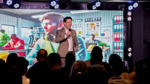 Rony Jabour speaking to a large audience in Boston, presenting on workplace safety and emergency preparedness during a live event, with a safety-themed visual on the screen behind him.
