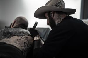 A photo of tattoo artist Dillon Forte at work tattooing a client
