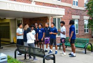 Two women conversing a group of RBC student-athletes.