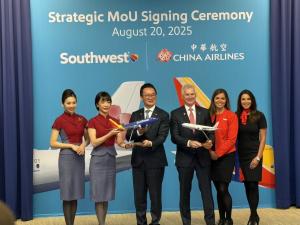  A group photo of China Airlines President Kevin Chen and Southwest CEO Bob Jordan. They are standing with two flight attendants, one from each airline, and two marketing professionals in business attire. Chen and Jordan are each holding a model of their 