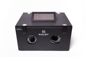 A closed black box where a screen and an area to insert hands with gloves can be seen to securely analyze mobile devices while blocking wireless signals.