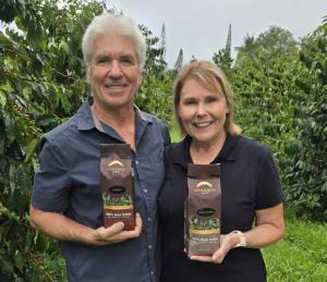 Steve and Joanie Wynn standing in the orchard of their Kona coffee farm