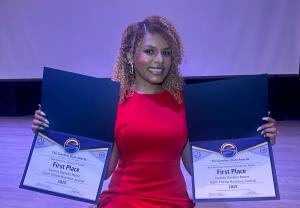 Cortney Danielle Moore dressed in red holding up her two first-place wins at the 2025 Sunshine State Awards.