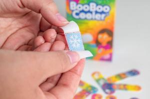 Close-up of BooBoo Cooler bandage being unwrapped, revealing the blue cooling layer that sits above the clear water bag inside.