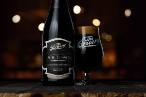 A bottle of The Bruery's Black Tuesday next to a glass of imperial stout.