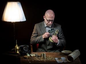 Antiquarian looking at the old bronze candlestick