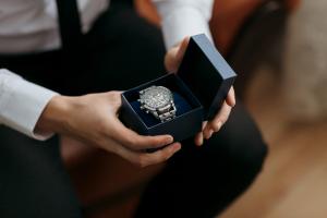 A man is holding a watch in a box.