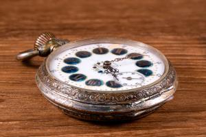 Elegant antique silver pocket watch with decorative dial and patina