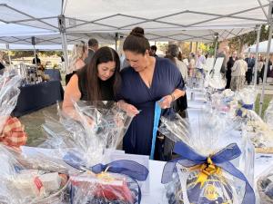 Two gala guests examine raffle baskets wrapped in cellophane at Maryvale’s Harvest of Hope Gala in Rosemead, California.