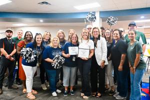 Mary Jo Johnson, CEO of Steam Commander, and Kimberly Wallace, Lamkin campus secretary, hold commemorative Adopt-a-School certificates with CFISD’s Dawn Tryon, Lamkin administration, and Steam Commander representatives.