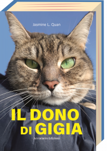 "I gatti sanno come ottenere il nostro amore senza mai chiederlo "Sulla copertina del libro 'Il Dono di Gigia', un'immagine di Gigia che fissa il lettore. I suoi intensi occhi verde smeraldo sono in primo piano, catturati mentre guardano dritto verso chi osserva, creando una connessione immediata e emotiva.