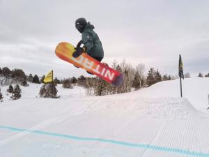 A man hangs in the air with his snowboard