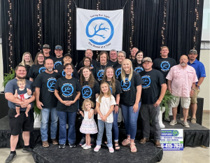 Large group photo of attendees at CRF’s Dining in the Dark fundraising event, smiling together.