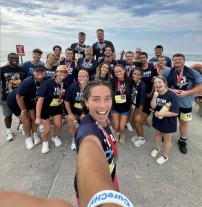 Large group selfie of Team Blake, part of Team CHM, smiling together at the Smith Point Sprint Triathlon.
