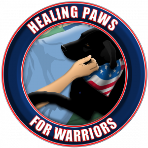Round patch with circular text reading Healing Paws for Warriors. Inside the patch is a person's hand petting a black dog wearing an American flag.