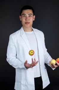 Dr Vincent in a white lab coat holding apples, representing Renovatio Bioscience’s antioxidant research and Australian-made health products.