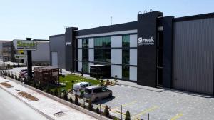 The EMO Hannover Fair, the global meeting point for the metalworking and manufacturing industry, once again brings together leading industry figures, innovative startups, and companies shaping the future of production technologies under the theme “Innovation in Manufacturing Exterior view of Simsek Makina Takim factory with glass and black facade, front garden, and parking area