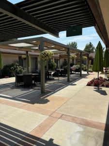 An outdoor courtyard at Ararat Gardens Post Acute featuring shaded seating areas, hanging flower baskets, and green umbrellas designed for resident comfort and community.
