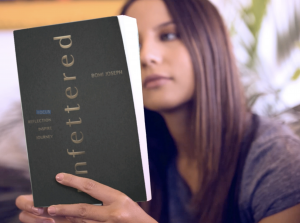 Young woman reading the book Unfettered by Dr. Bomi Joseph, symbolizing vitality and clarity.