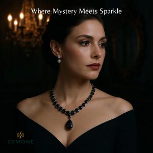 Woman wearing a large black lab grown diamond necklace with a tear-drop pendant and lab grown diamond halo stud earrings in a dark, luxury setting. High-fashion, gothic diamond jewelry by GEMONE.