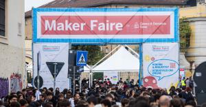 Entrance Gate Maker Faire Rome banner and a large crowd of attendees at Gazometro Ostiense, Rome