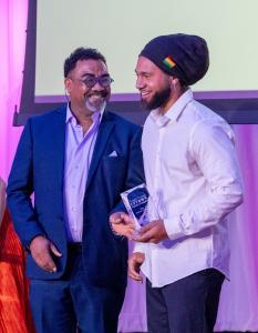 Micah Morgan standing on stage receiving an award at the Temple Terrace Gala, celebrating community recognition.