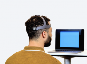 A patient is wearing The NeckCare System device and following instructions on the laptop screen.