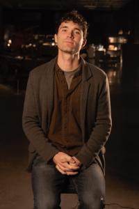 Photo of the artist John Guillemette standing with a small smile.