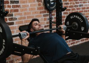 Man doing an incline benchpress while using a pair of Evolve Grips ergonomic gym grips