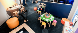 Colorful play area featuring musical instruments, stools, and interactive tables designed for children's creative exploration.