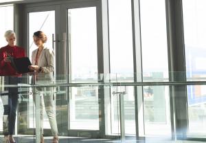 Two women standing next to commercial glass.