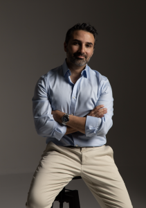 Dr. Masoud Saman, MD FACS, a leading rhinoplasty innovator and double board-certified facial plastic surgeon, has been selected as one of only six surgeons worldwide to perform live ultrasonic preservation rhinoplasty at the Montpellier Live Rhinoplasty Course in France Masoud Saman one of the best new york and american rhinoplasty and facelift surgeons with dual board certification in a white shirt smiling