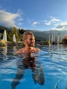 In a digital world overflowing with filters and fast fame, Swiss lifestyle creator Mike Arens is redefining what influence truly means Mike Arens in an outdoor pool at Forsthofalm Leogang with mountain backdrop, representing Swiss luxury and mindful lifestyle aesthetics.